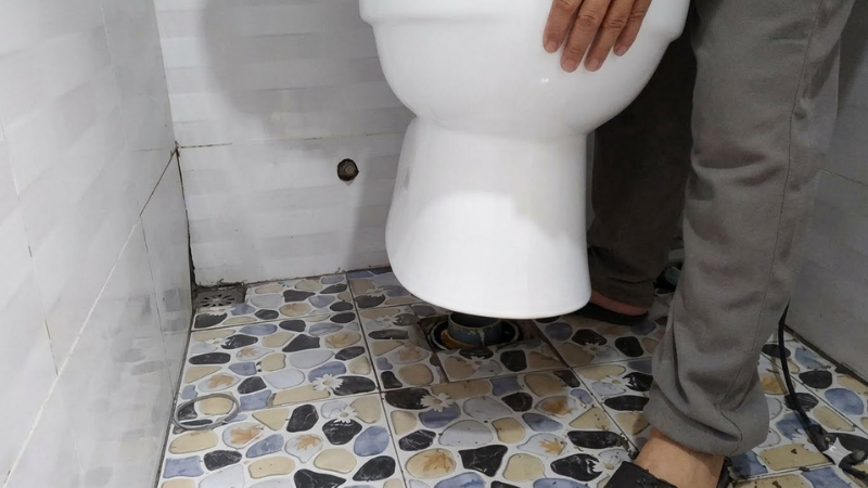 Cố định thân bồn cầu xuống sàn hoàn thiện