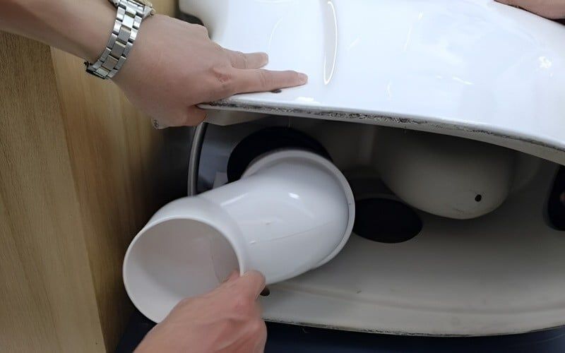 Tiến hành lắp thiết bị chỉnh lệch tâm bồn cầu vào vị trí ống chờ và cố định bằng keo hoặc gioăng cao su