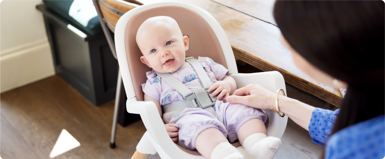 Mum sitting on the floor next to baby in the Joie Serina 2in1 baby swing