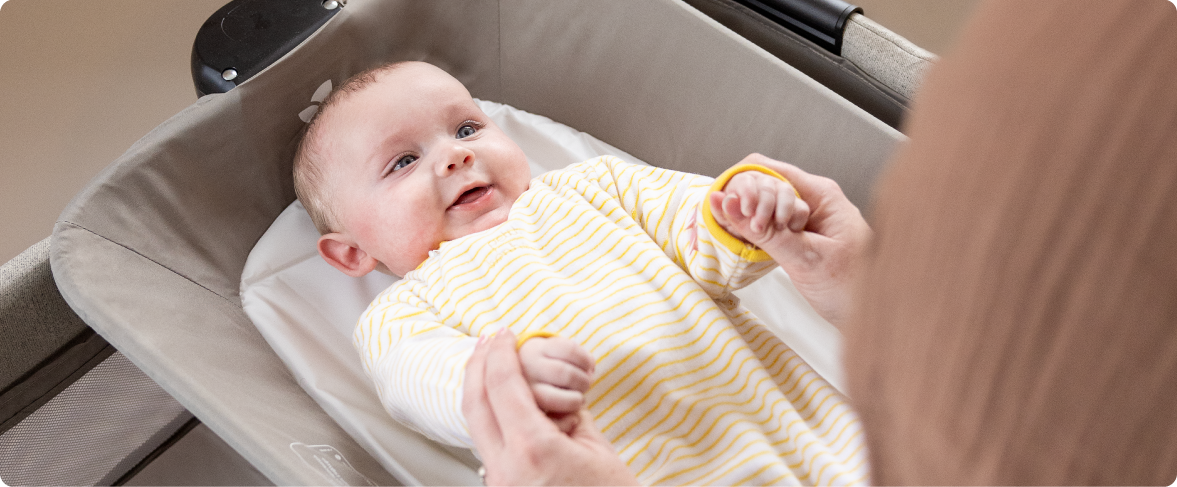 Mum sitting on the floor next to baby in the Joie Serina 2in1 baby swing