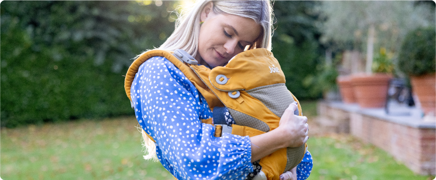 Mum sitting on the floor next to baby in the Joie Serina 2in1 baby swing