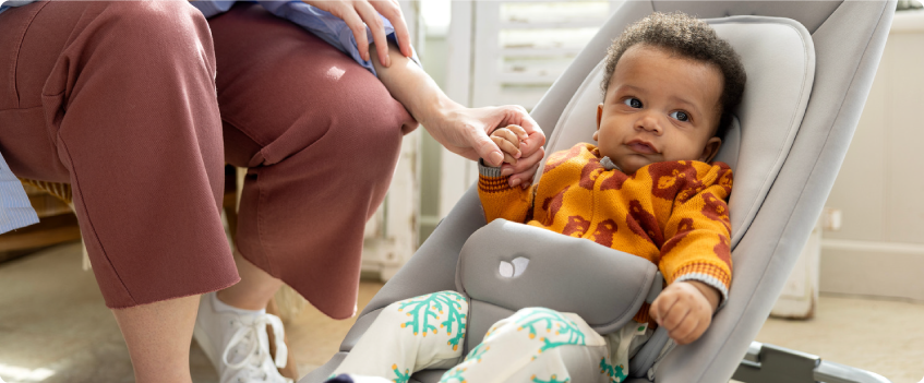 Mum sitting on the floor next to baby in the Joie Serina 2in1 baby swing