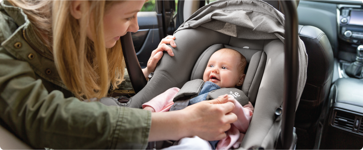Mum sitting on the floor next to baby in the Joie Serina 2in1 baby swing