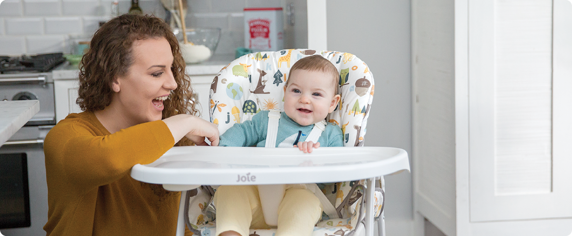 Mum sitting on the floor next to baby in the Joie Serina 2in1 baby swing