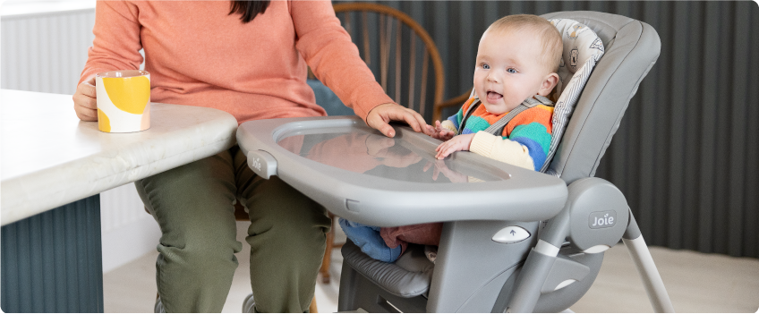 Mum sitting on the floor next to baby in the Joie Serina 2in1 baby swing