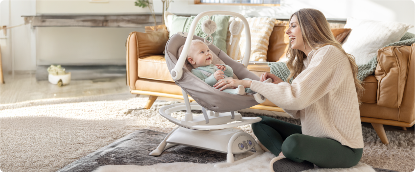 Mum sitting on the floor next to baby in the Joie Serina 2in1 baby swing