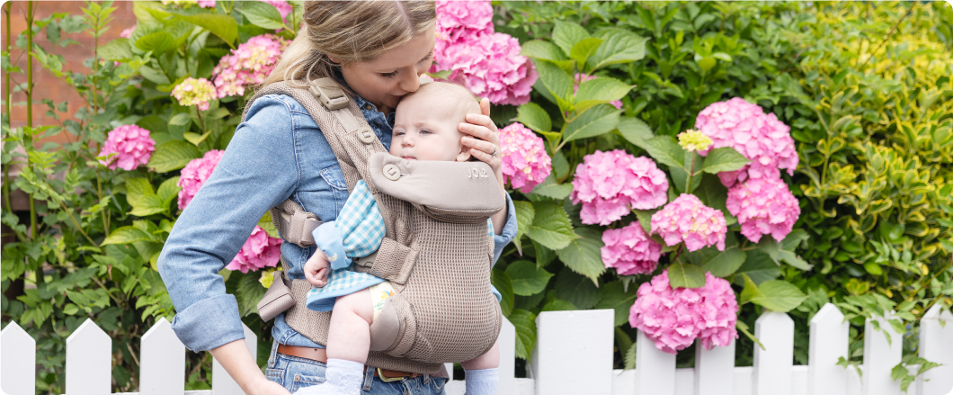 Mum sitting on the floor next to baby in the Joie Serina 2in1 baby swing