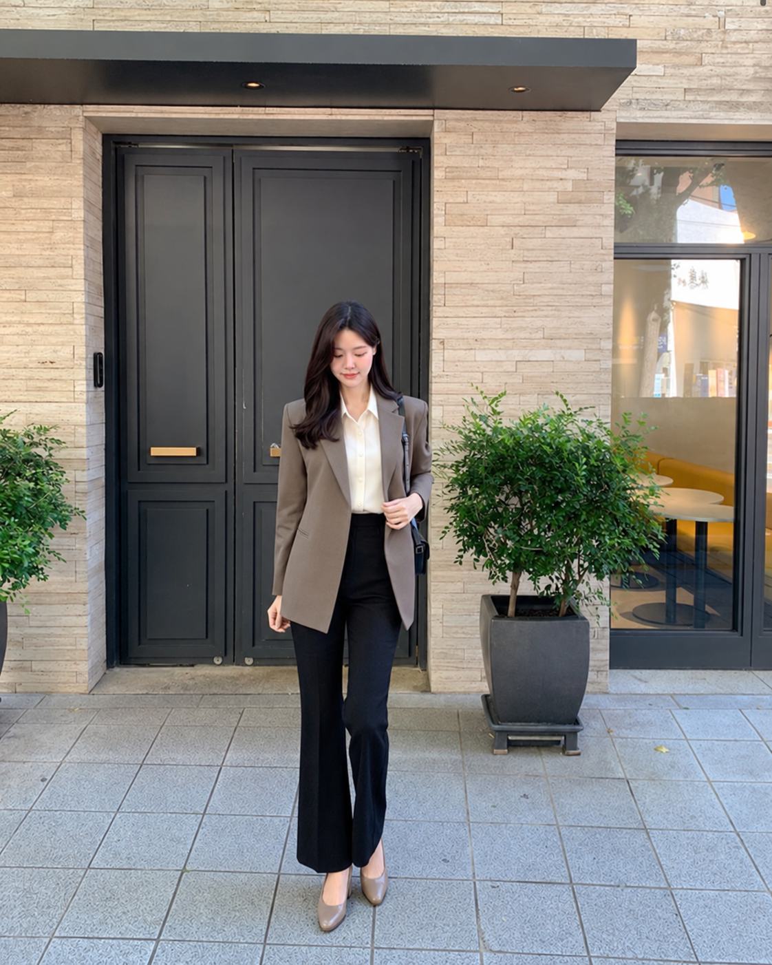 Blazer màu taupe phối blouse kín đáo, quần tây đen và giày gót thấp khi phỏng vấn