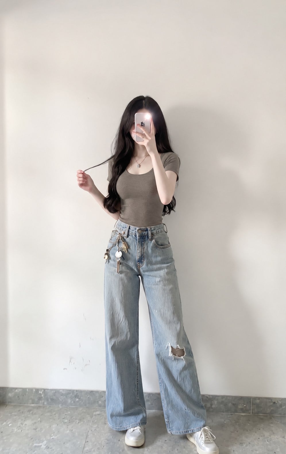 Áo taupe dáng gọn phối jeans xanh và sneaker trắng cho trang phục hằng ngày.