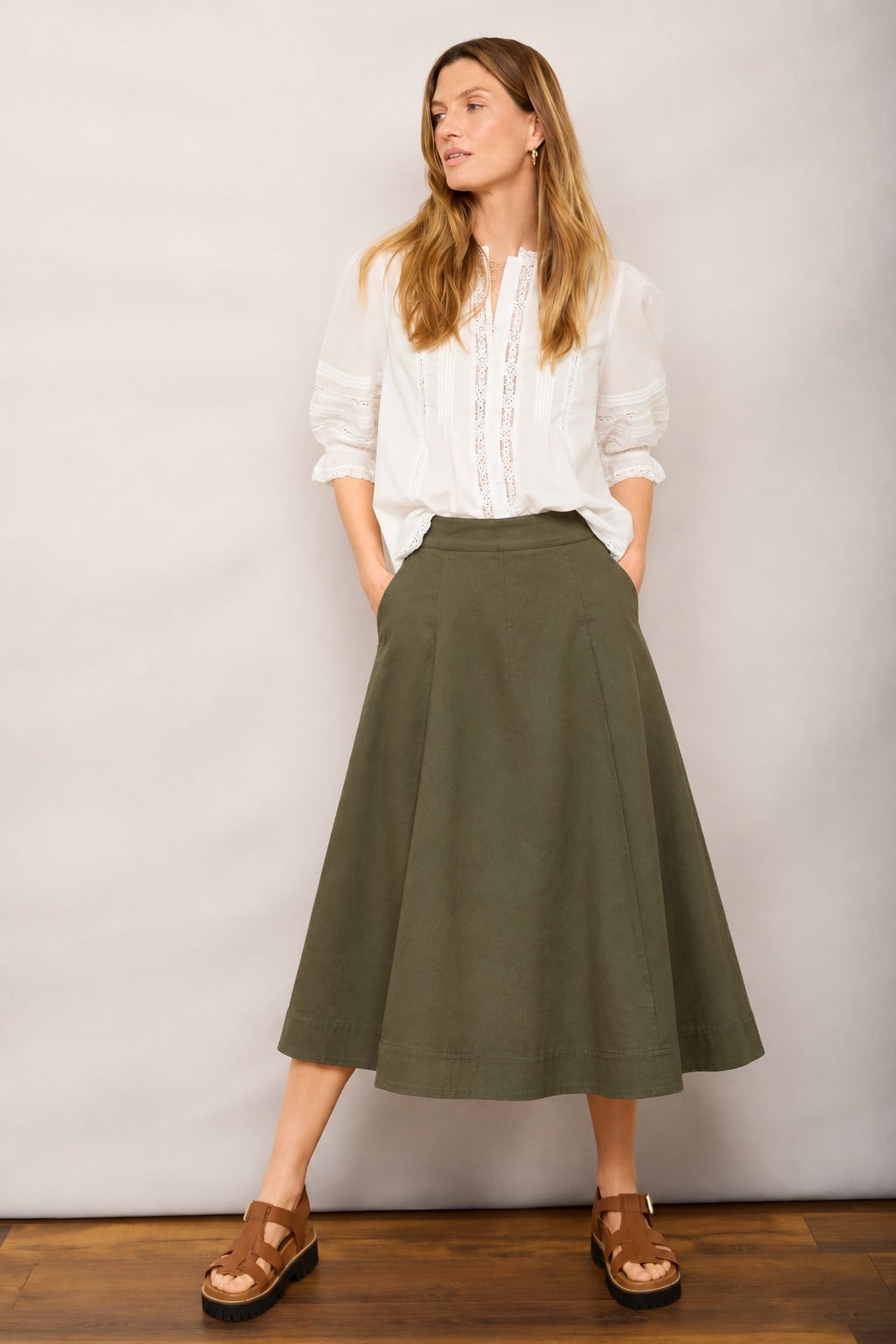 Blouse trắng tay lỡ phối chân váy chữ A màu olive và sandal nâu