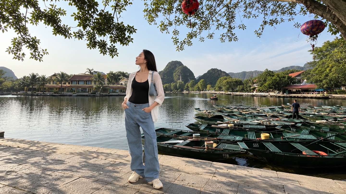 Áo hai dây đen, quần jeans ống rộng và sơ mi trắng tại bến thuyền