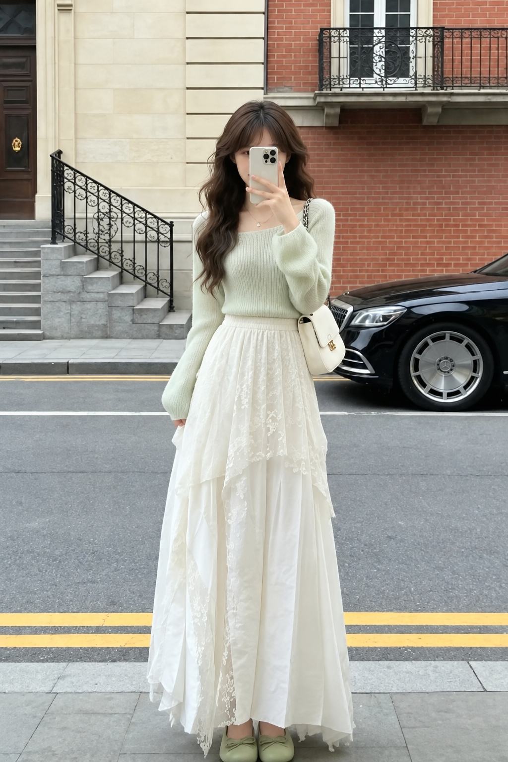 Knit top xanh nhạt ôm vừa, gấu áo gọn ở cạp chân váy ren dài.