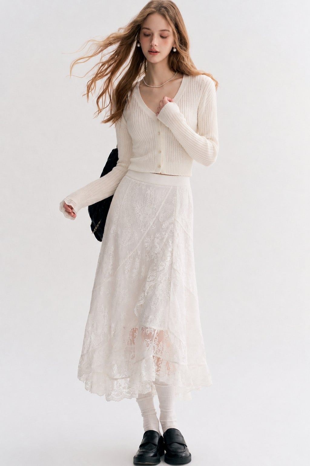 Cardigan ivory ngắn cài khuy phối chân váy ren trắng dài và loafer đen.