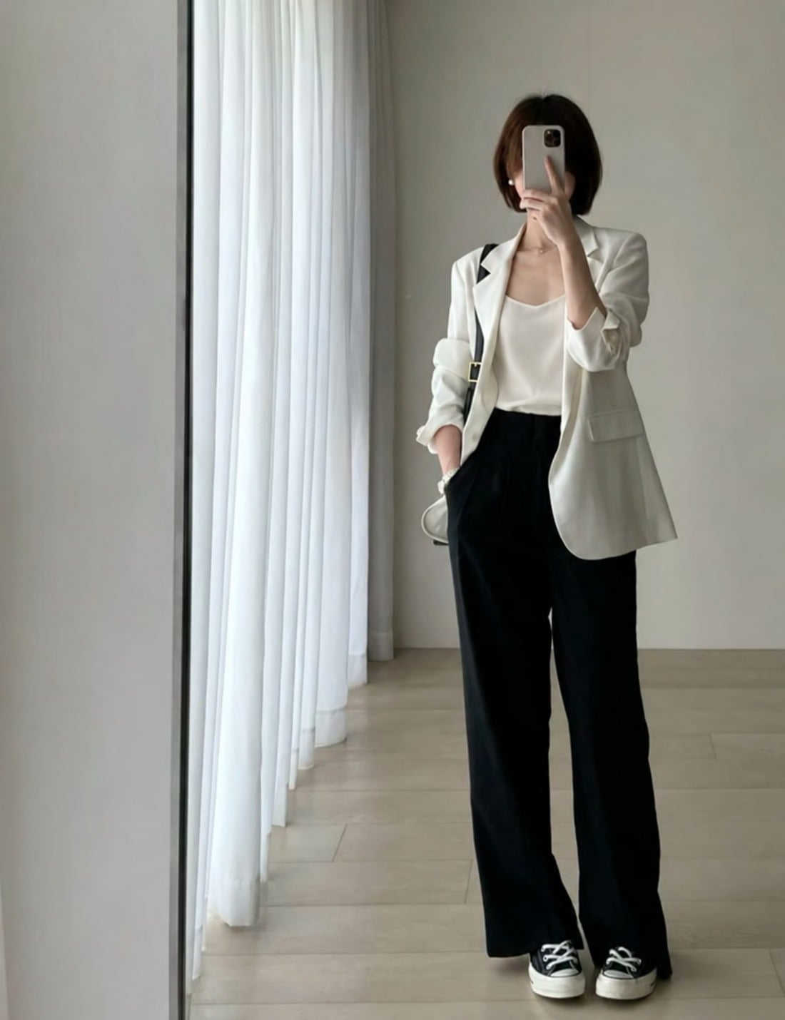 Áo hai dây màu kem mặc cùng blazer mềm và quần đen dáng suông