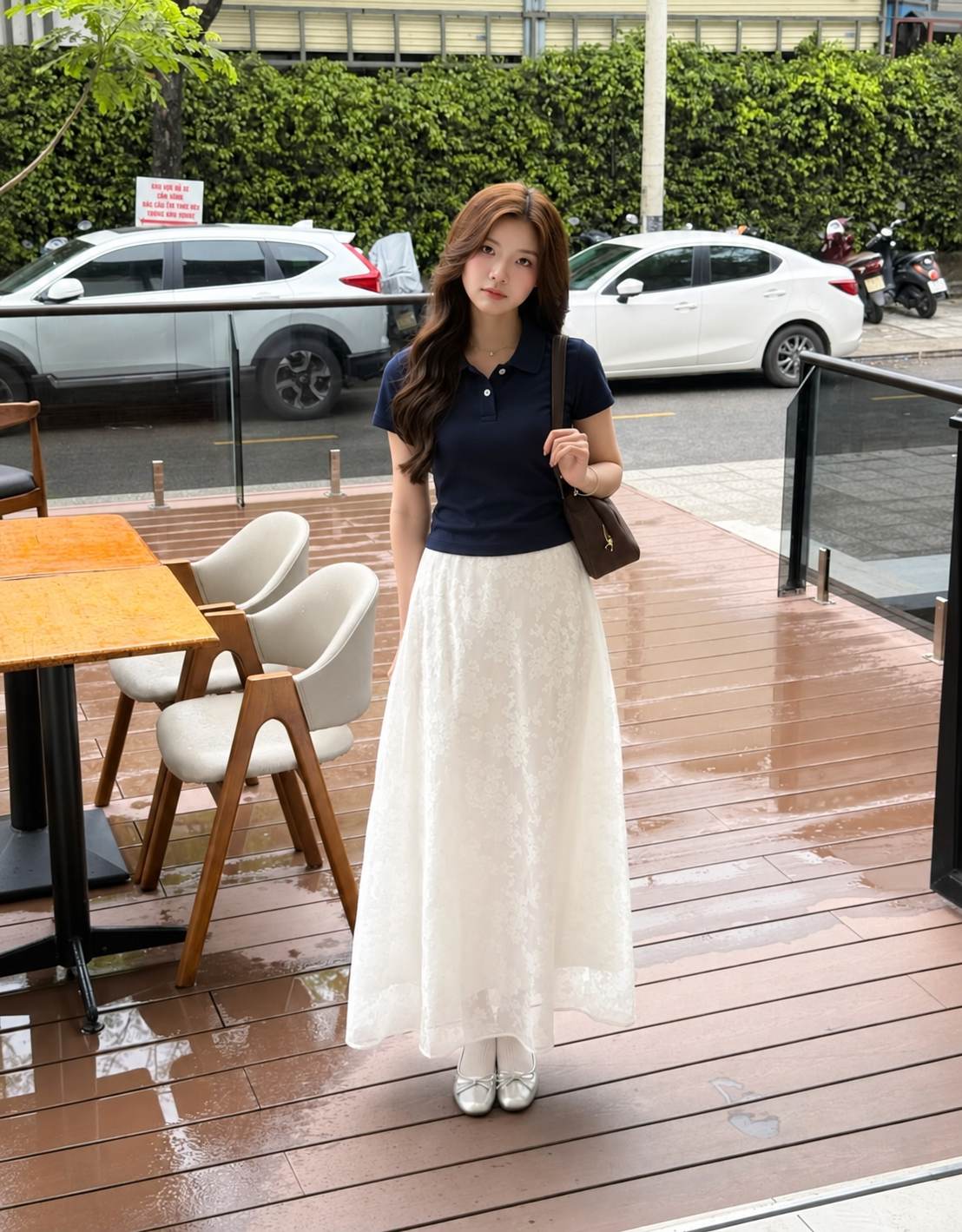 Áo polo navy dáng gọn phối chân váy ren trắng dài và giày bệt.