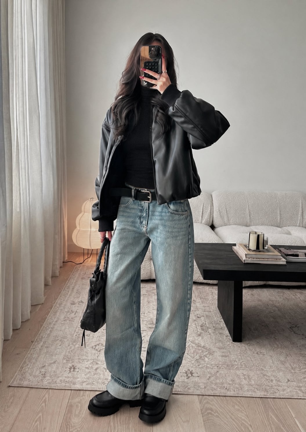 Áo cổ lọ đen phối áo khoác da và quần denim cho nữ