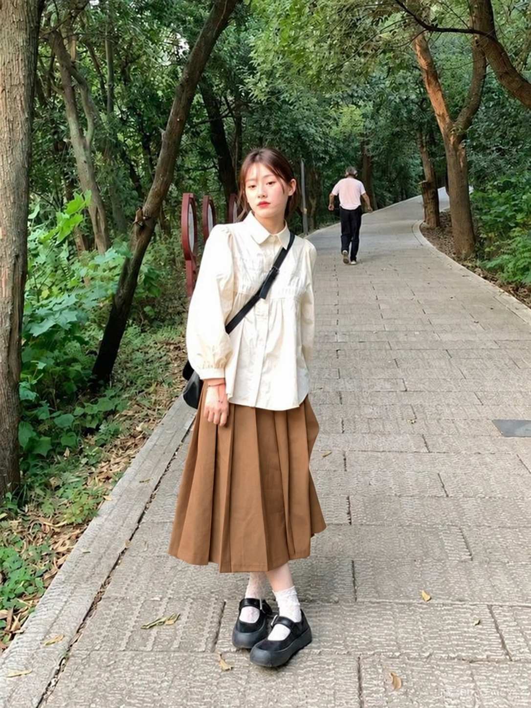 Chân váy nâu caramel xếp ly phối blouse sáng màu và giày Mary Jane