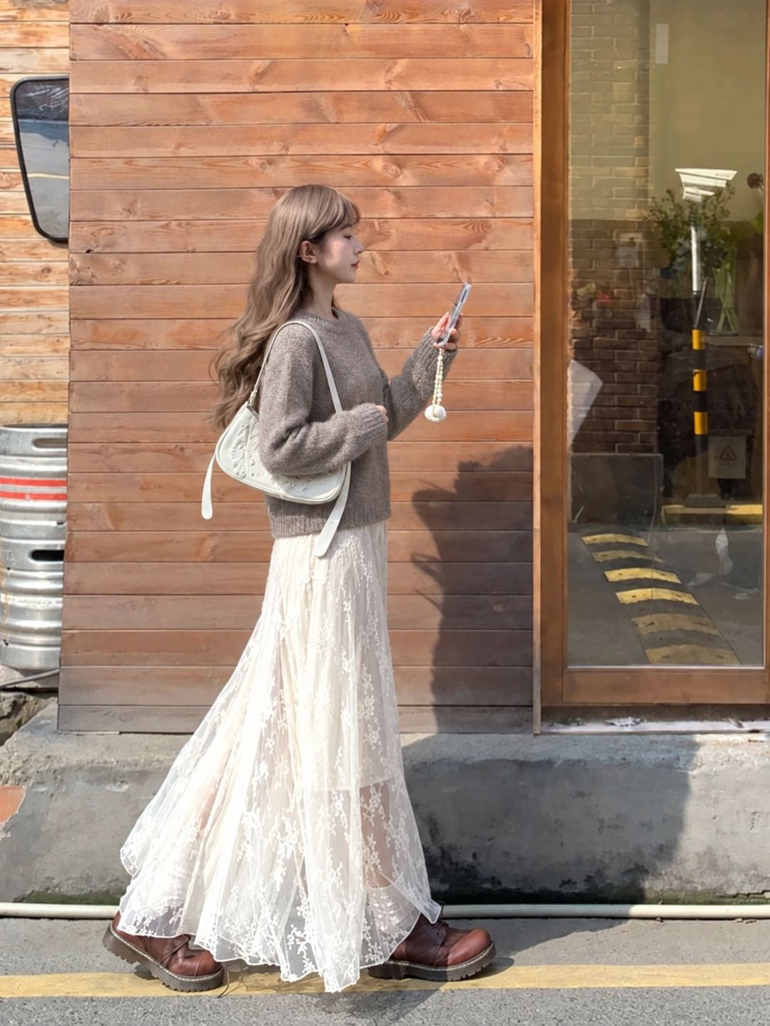 Sweater cổ tròn gọn phối chân váy ren dài màu kem trong ngày mát.