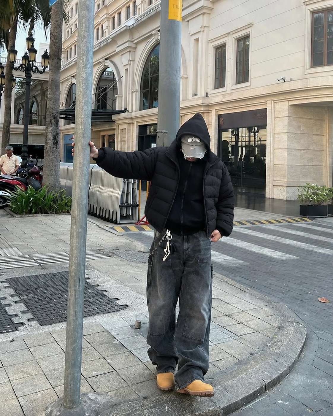 Hoodie nam phối áo phao đen, jeans và boots màu nâu
