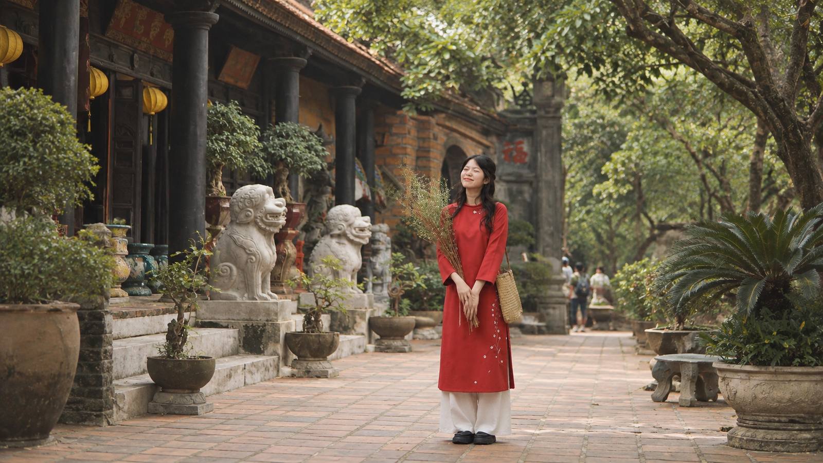 Áo dài cách tân đỏ phối quần trắng và giày bệt tại sân đền