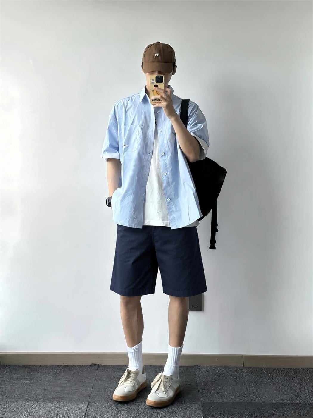 Nam mặc áo thun trắng, sơ mi xanh nhạt khoác ngoài và quần short navy