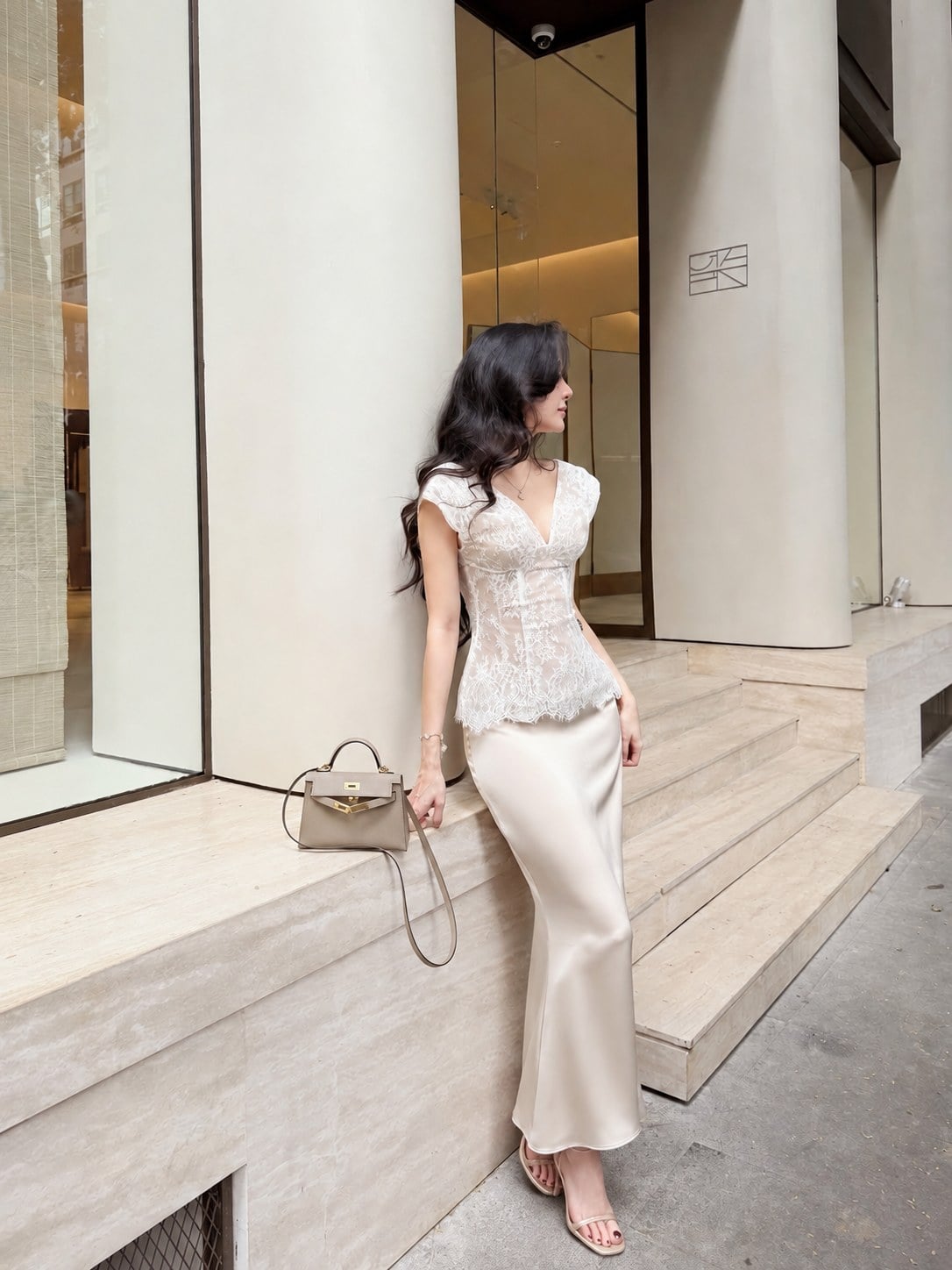 Chân váy lụa kem phối áo ren trắng và sandal nude tạo tổng thể nhẹ nhàng
