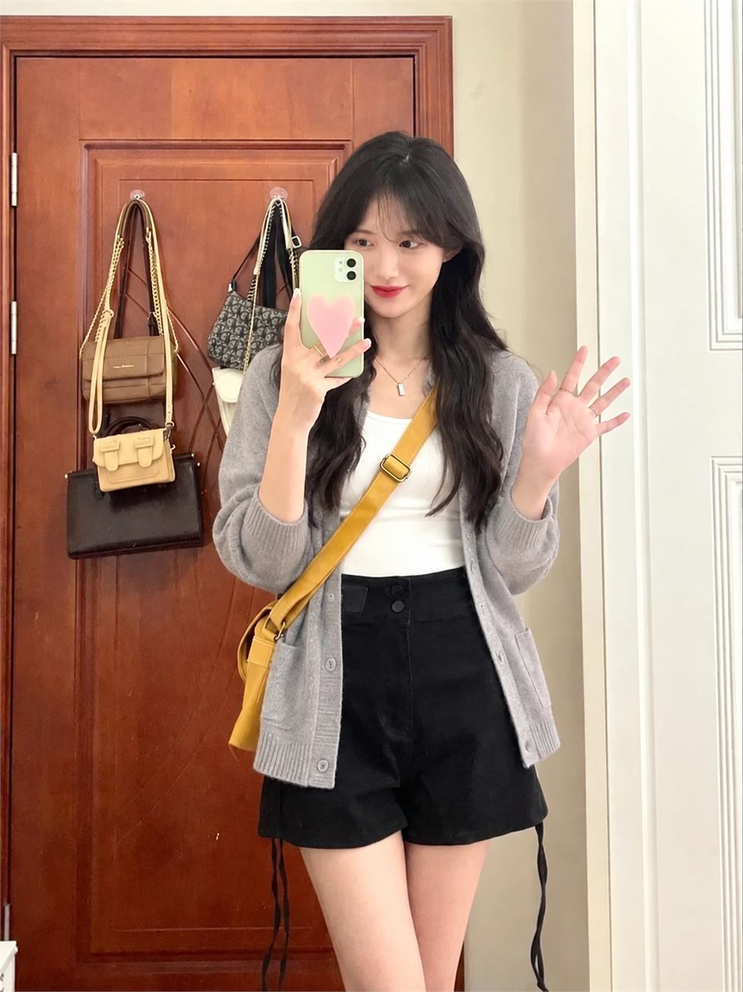 Cardigan xám nhạt phối áo trắng và quần sooc đen cạp cao tạo lớp mặc nhẹ
