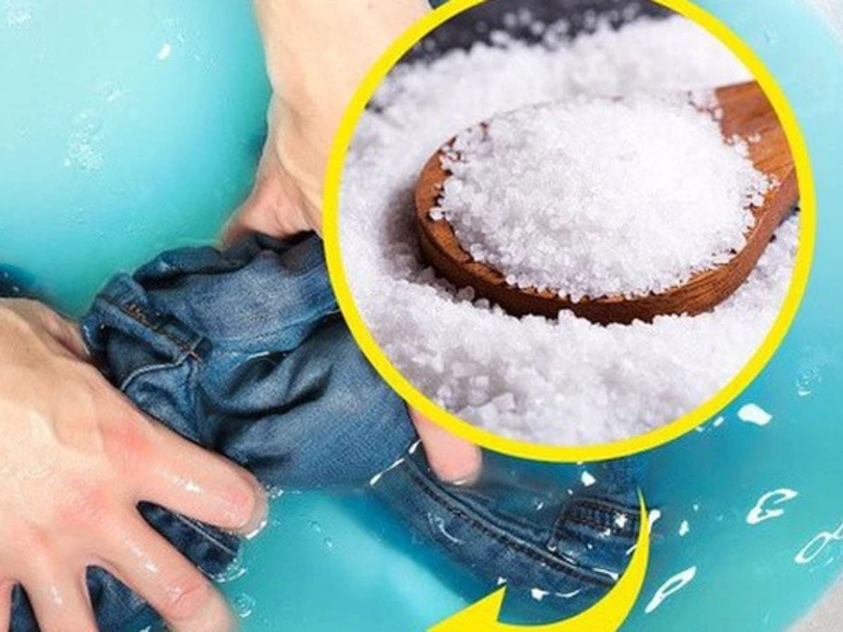 Bàn tay ngâm quần jean xanh trong chậu nước kèm hình phóng to các hạt muối trắng.