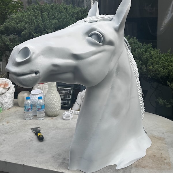 Mô hình đầu ngựa khổ lớn in 3D hoàn thiện bề mặt trước khi sơn, đặt cạnh chai nước để so tỉ lệ