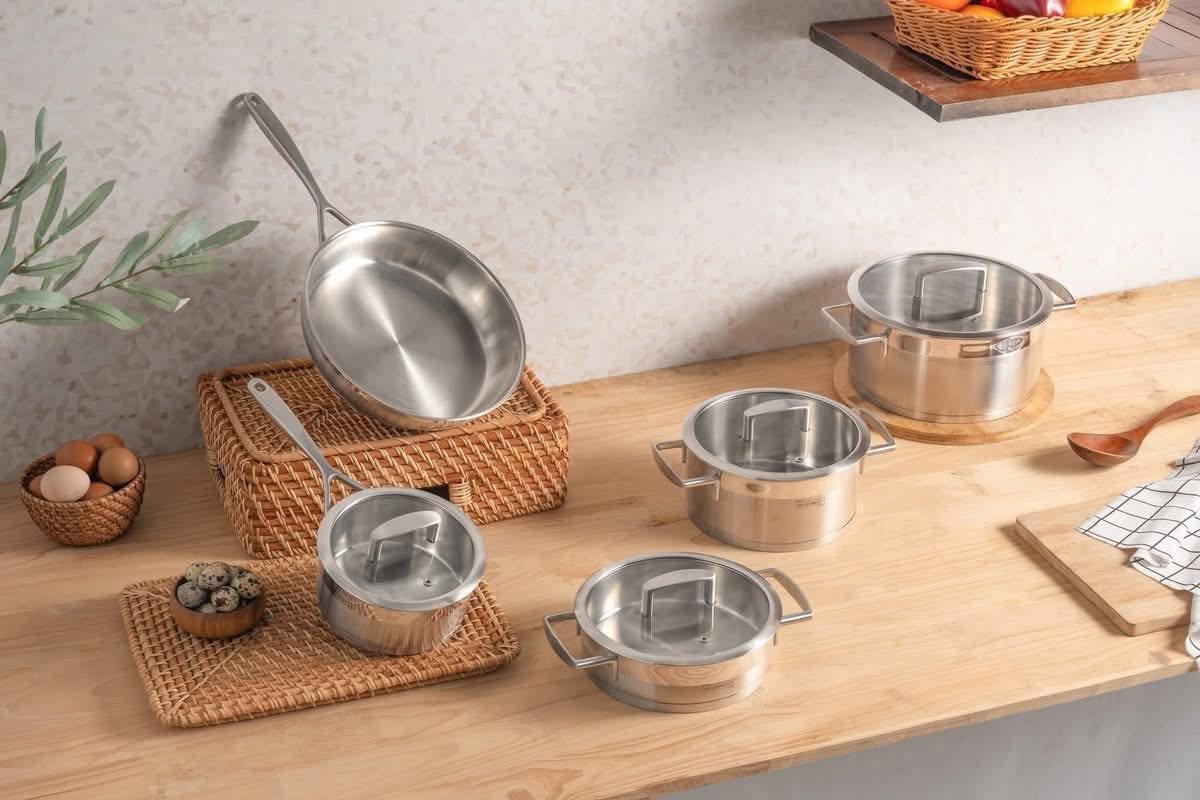 Bộ nồi Michelangelo Signature 5 món bố trí trên bàn gỗ với đầy đủ các kích thước nồi và chảo