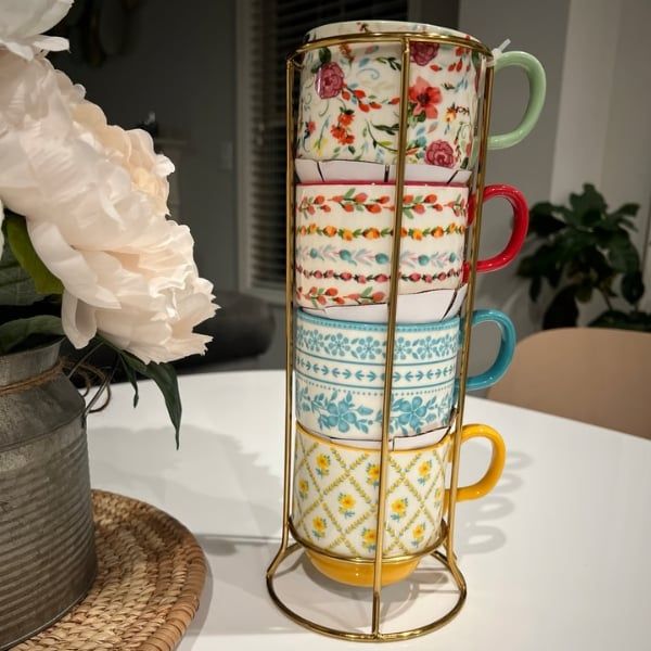 bốn chiếc cốc The Pioneer Woman xinh xắn được trang trí bằng họa tiết hoa rực rỡ, cùng với giá đỡ giúp bạn dễ dàng lấy những chiếc cốc yêu thích