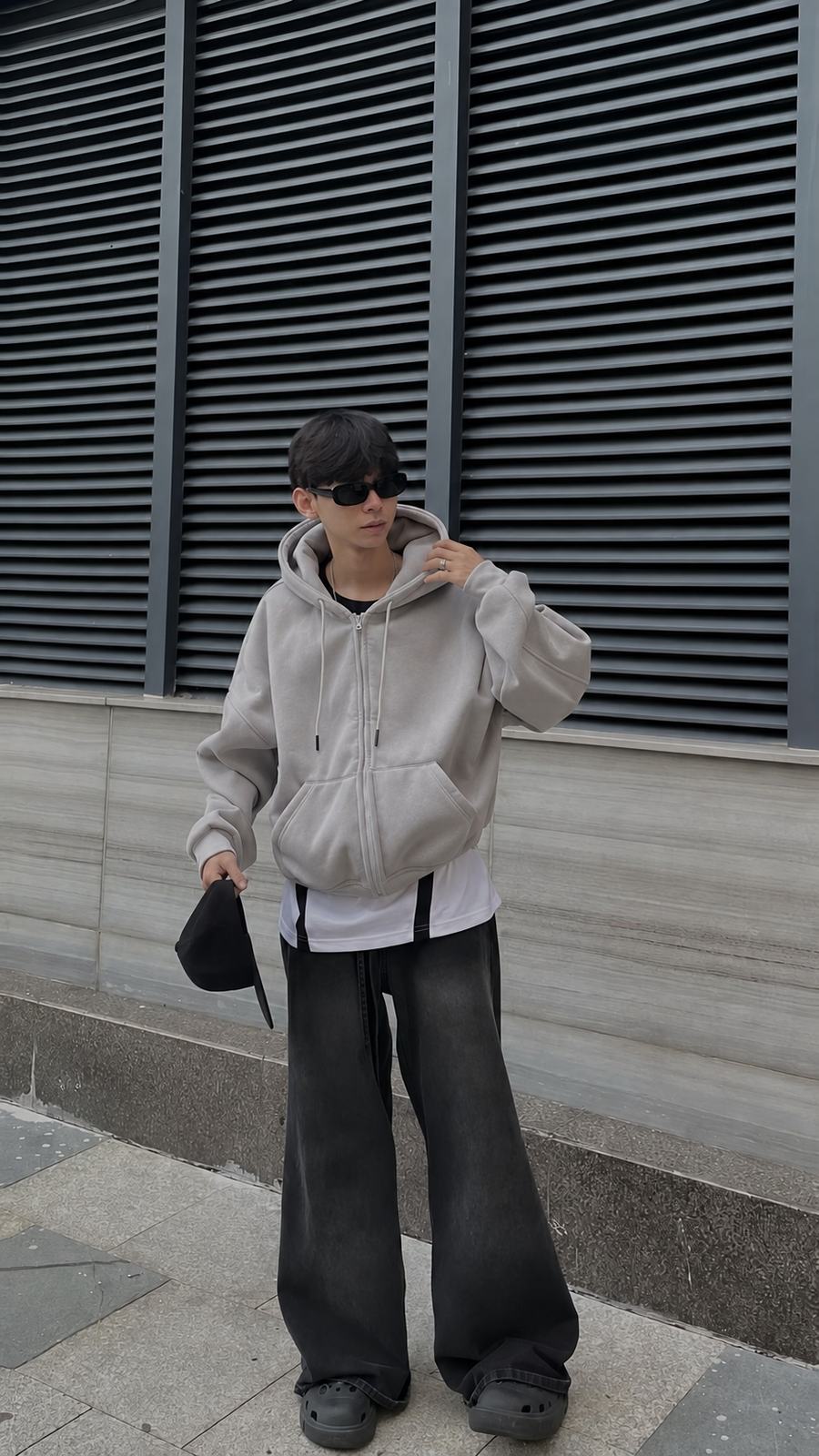 Hoodie xám trơn có bo gấu gom vải ở hông khi mặc trên người