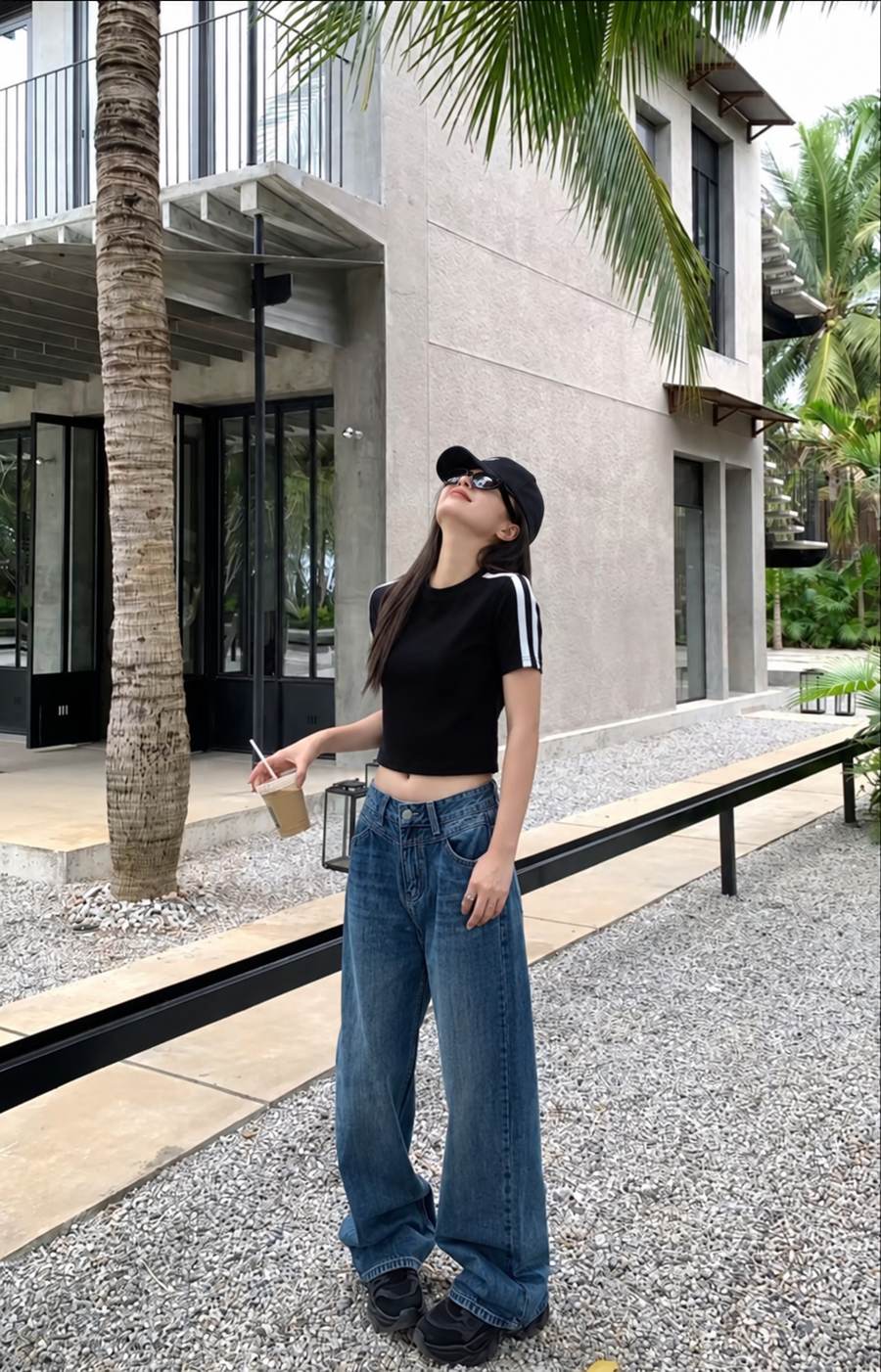 Baby tee đen, jeans suông và nón bóng chày khi dạo phố