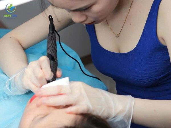 Hình ảnh chuyên viên đang tỉ mỉ thực hiện kỹ thuật làm đẹp tại địa chỉ phun môi cam sữa uy tín.