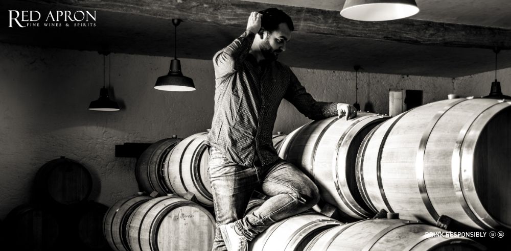 Ly rượu vang đỏ Berrouet trên bàn, thể hiện phong cách rượu vang Bordeaux tinh tế, cân bằng và trung thực với thổ nhưỡng Saint Emilion, Lalande de Pomerol, Montagne Saint Emilion.