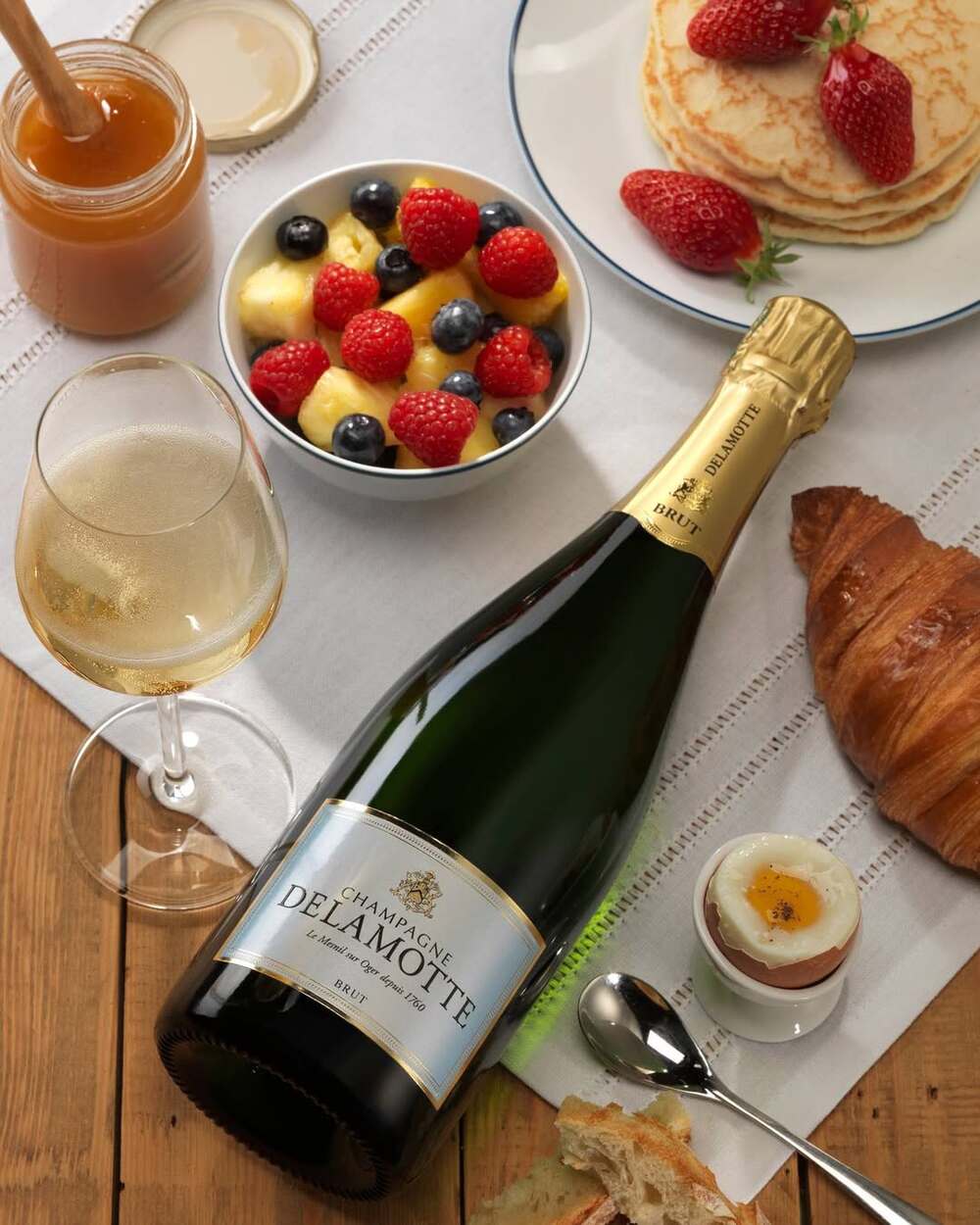 Chai Champagne Delamotte Brut chụp cận cảnh, nhấn mạnh phong cách cân bằng và linh hoạt.