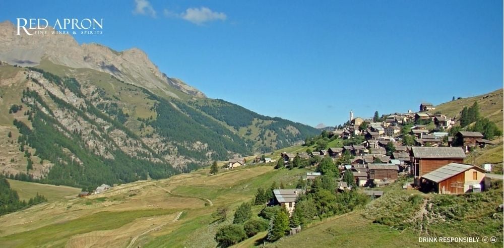 Hình phong cảnh làng Saint-Véran với ruộng nho, đồi cây và nhà cổ, minh họa tiểu vùng rượu vang Saint-Véran trong Maconnais.