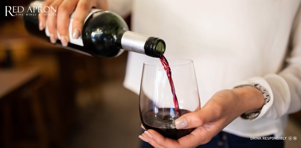 Ly rượu vang đỏ màu trong, người ngửi hương để phân biệt rượu thật – giả bằng giác quan.