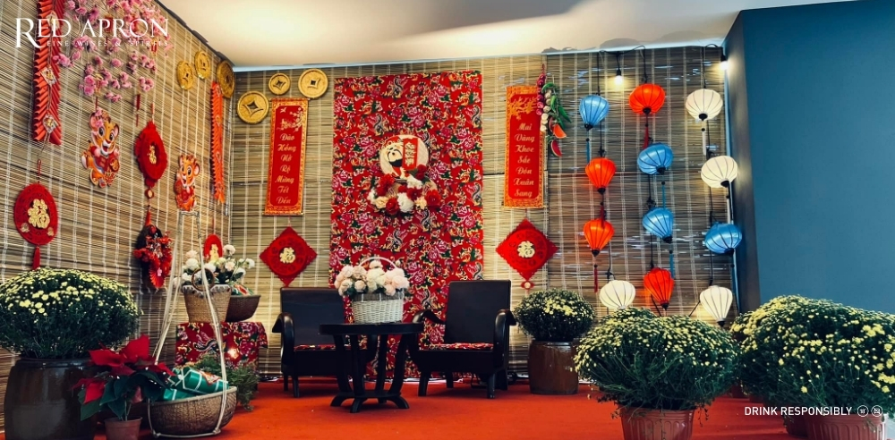 Căn phòng trang trí Tết với nhiều chi tiết đỏ và vàng, có cây cảnh và đồ treo trang trí, gợi ý quà Tết handmade dạng đồ decor