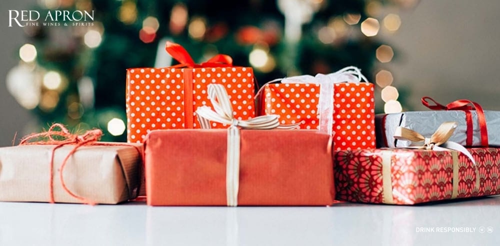 Nhiều hộp quà được gói bằng giấy đỏ và giấy kraft kèm ruy băng, minh họa xu hướng quà Tết handmade 2026