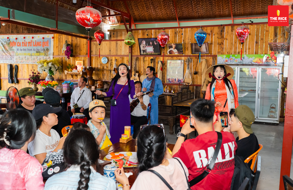 Guests sit and enjoy traditional Vietnamese folk music while having fruit to accompany their meal