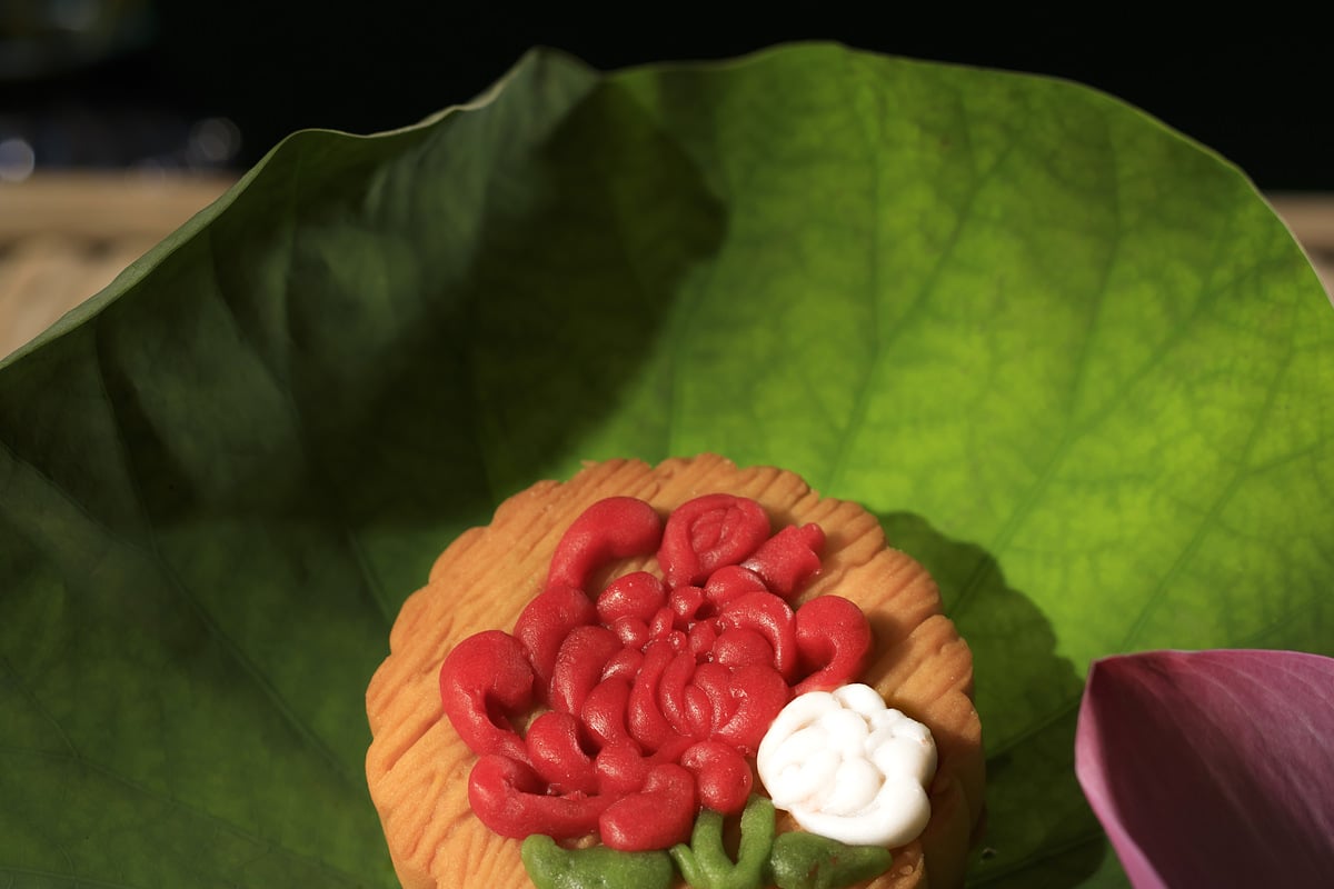 Bánh nướng hình hoa sen đỏ đặt trên lá sen