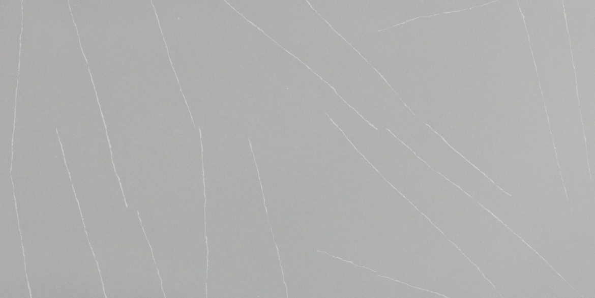 Calacatta Dramatic features a smooth cool-grey background accented by thin, crisp white veins that create a clean, modern, and subtly striking look for contemporary interiors.