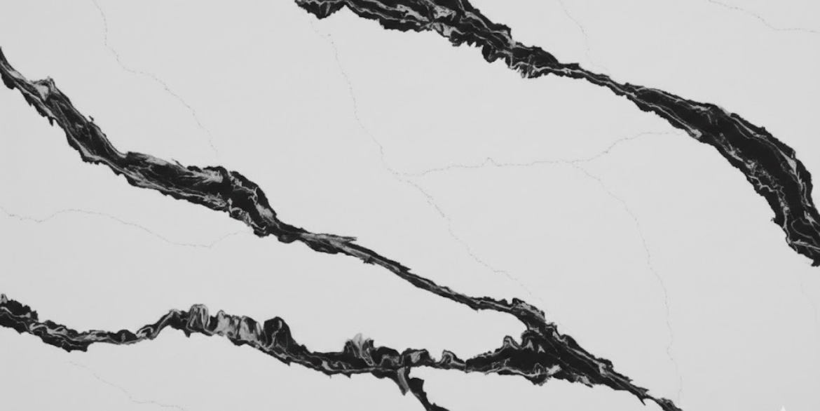 Calacatta Pumice features a pure white background cut by bold, charcoal-black veins that create a striking, high-contrast marble look.