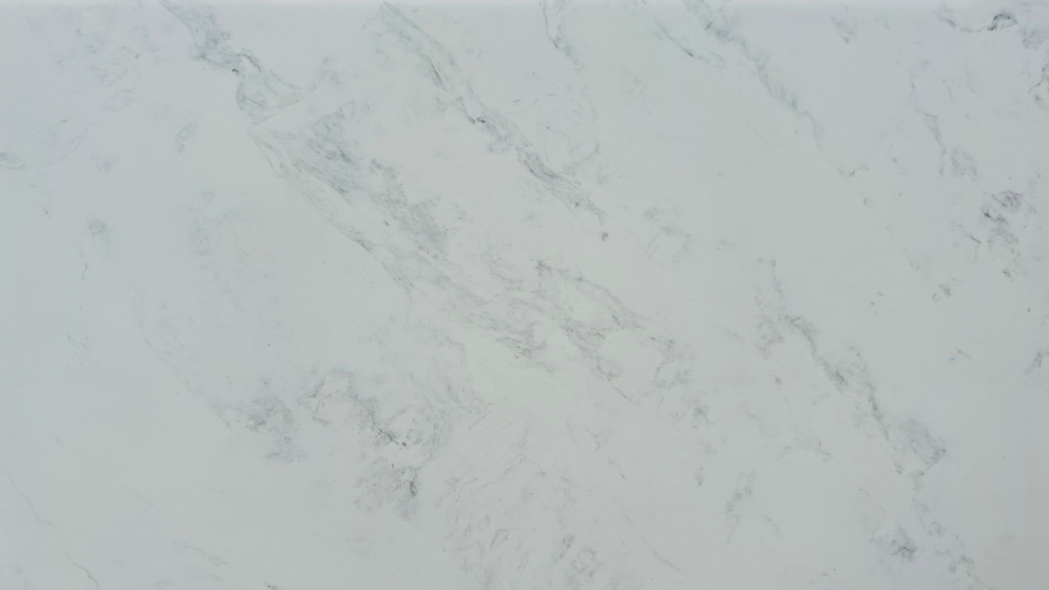 Calacatta Aquamarine features a bright white background with soft, flowing grey veining that moves naturally across the slab.