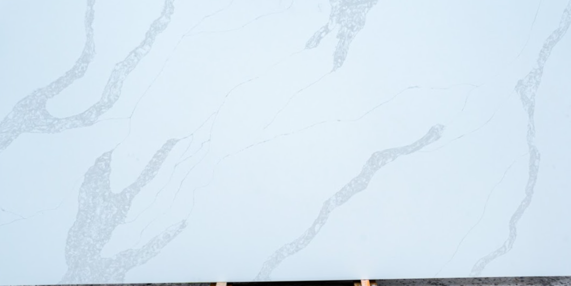 Calacatta Bianco Bella quartz slab with bright white background and bold flowing grey veining for luxury kitchen countertops and interior surfaces