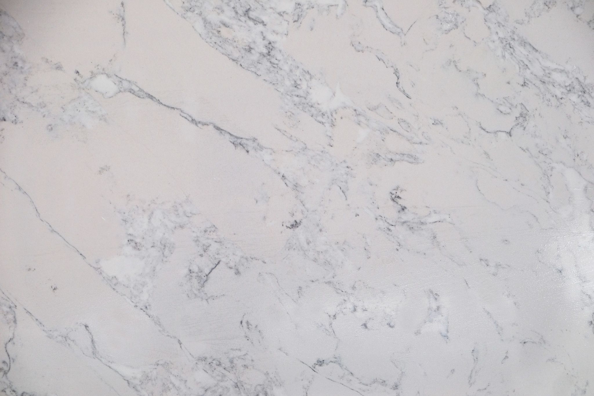 Calacatta FiJi features a bright white background with dynamic grey veining that flows naturally across the surface, creating a bold yet elegant marble-inspired look