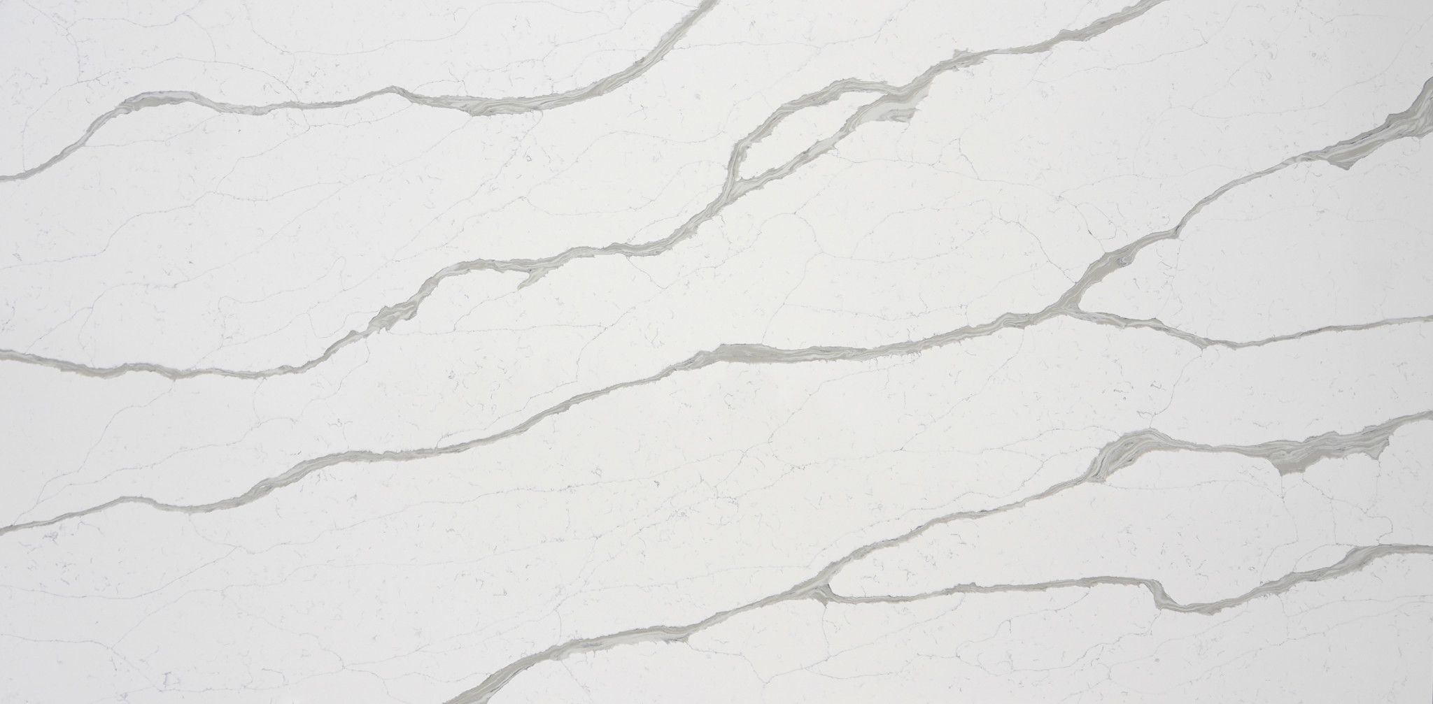 Calacatta Laguna features a bright white background with soft, wavy grey veining that flows gently across the slab, creating a calm and modern marble look ideal for kitchen countertops, islands, vanities and wall applications.