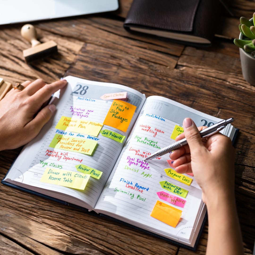 Giấy note dán trên sổ planner để ghi chú công việc