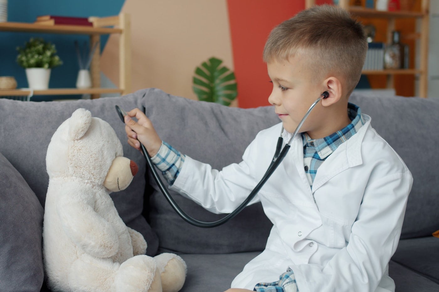 Bé trai đóng vai bác sĩ, khám cho gấu bông bằng ống nghe